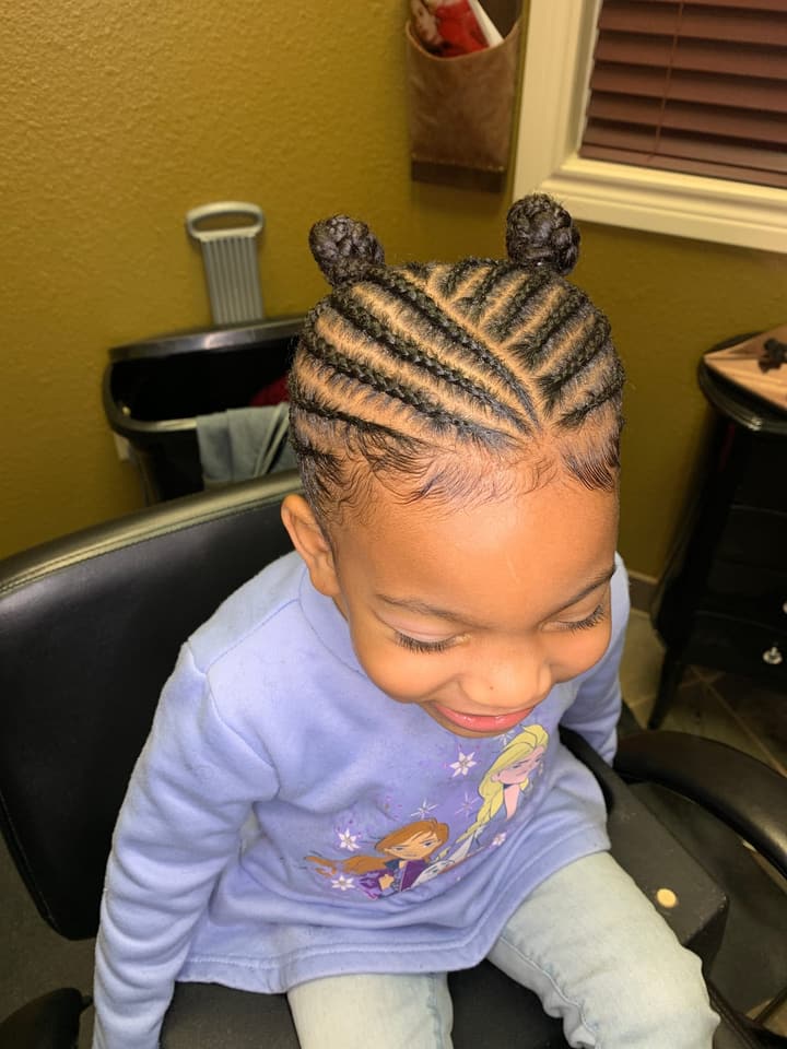 Child’s cornrows finished with two buns